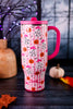 Ghost Town 30oz Mega Mug in pink with Halloween pumpkins and ghost pattern displayed on a dark tabletop with autumn decor