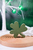 Green wooden clover block from Set of 3 Decorative Wooden Clover Blocks on carved wooden tray with blurred background