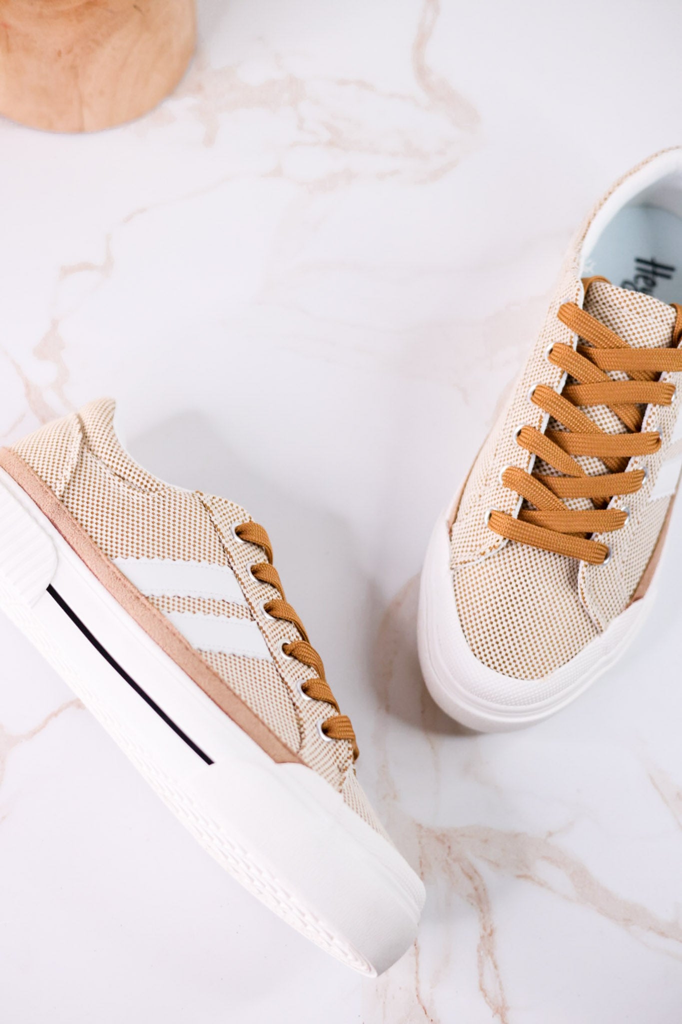 That's Her Tan Tweed Sneakers with white side stripes and tan laces shown on a marble background with natural light