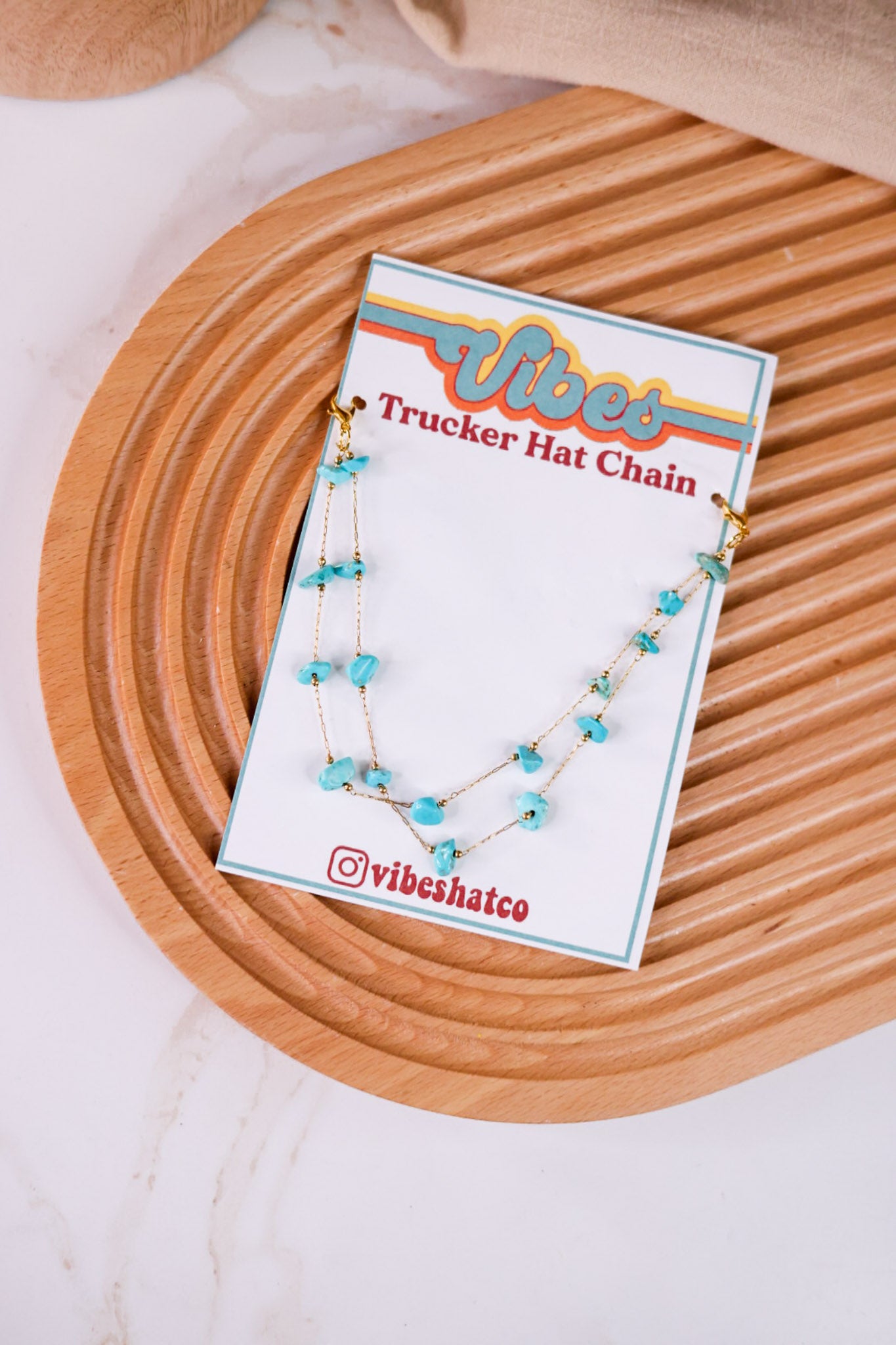 Turquoise Trucker Hat Chain with irregular turquoise stones on delicate gold chain displayed on wooden tray background