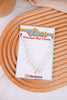 White Turquoise Trucker Hat Chain with white beads and silver links displayed on branded card on wooden textured surface