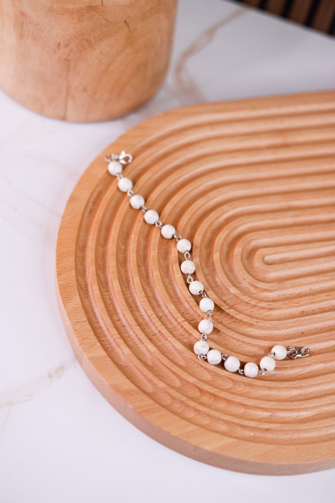White Turquoise Trucker Hat Chain with white beads and silver accents displayed on textured wooden tray accessory
