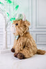 Side profile of Lush St. Patrick's Day Highland Cow Tabletop Sitter wearing green plaid hat and bow tie on marble surface