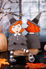 Two paper cutout witches with red hair and black hats on a Halloween-themed background.