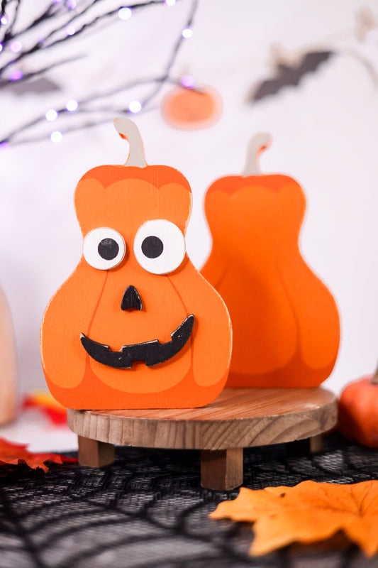 Halloween-themed paper pumpkin craft on a wooden stand with decorative background