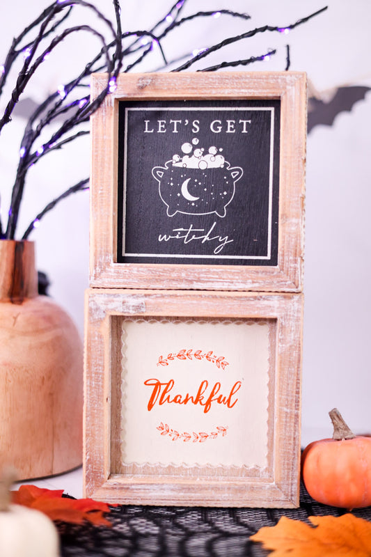 Two wooden picture frames with Halloween-themed prints on a decorative background.