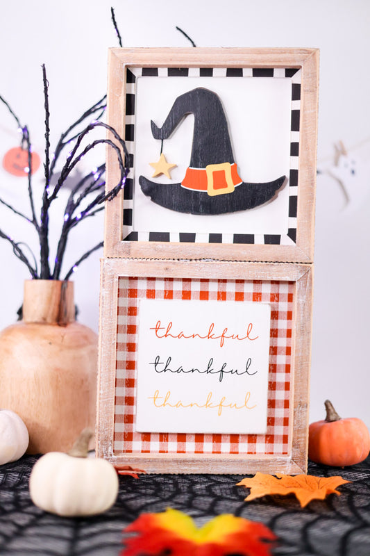 Decorative sign with witch hat and 'thankful' text, surrounded by Halloween-themed decor.