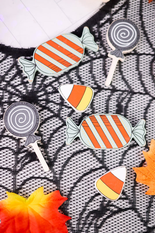 Halloween-themed ledgies including candy corn, a lollipop, and a witch hat on a patterned background.