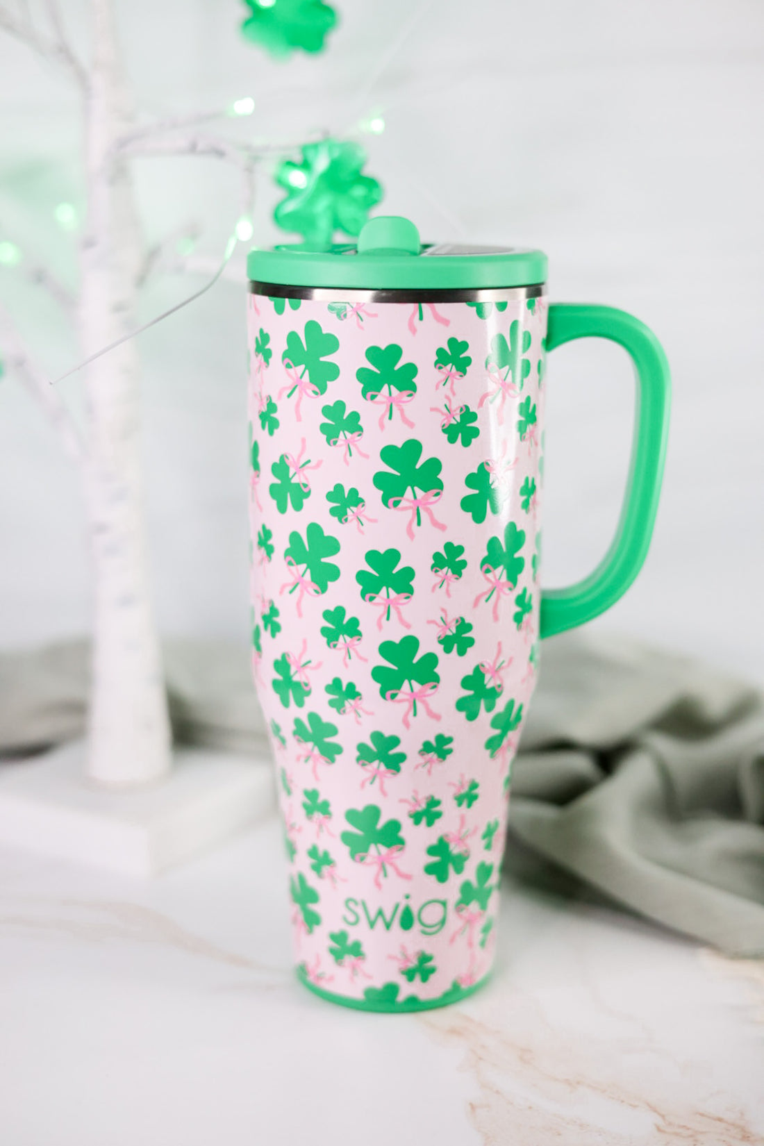 Clover Crush 40oz Mega Mug with bright green handle and shamrock pattern on a light pink background on marble surface