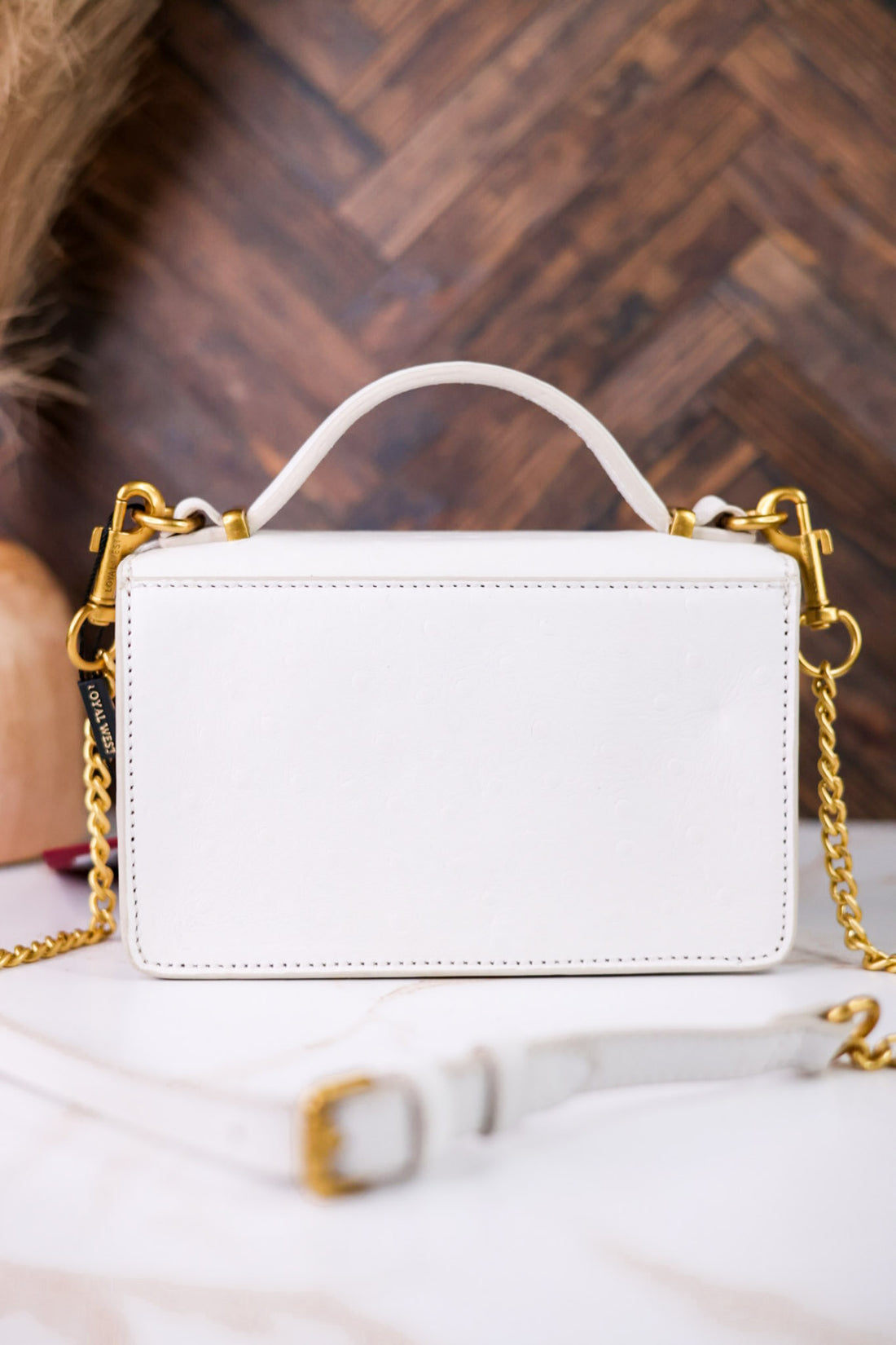 Rear view of Valencia Ostrich Leather White Bag highlighting smooth leather and gold chain strap details