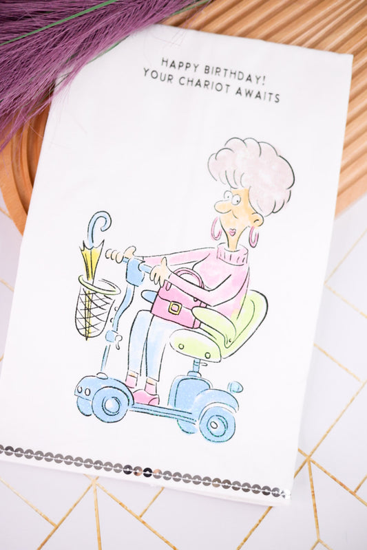 Your Chariot Awaits Glittery Kitchen Towel featuring a humorous birthday illustration of a woman riding a mobility scooter with a cocktail glass