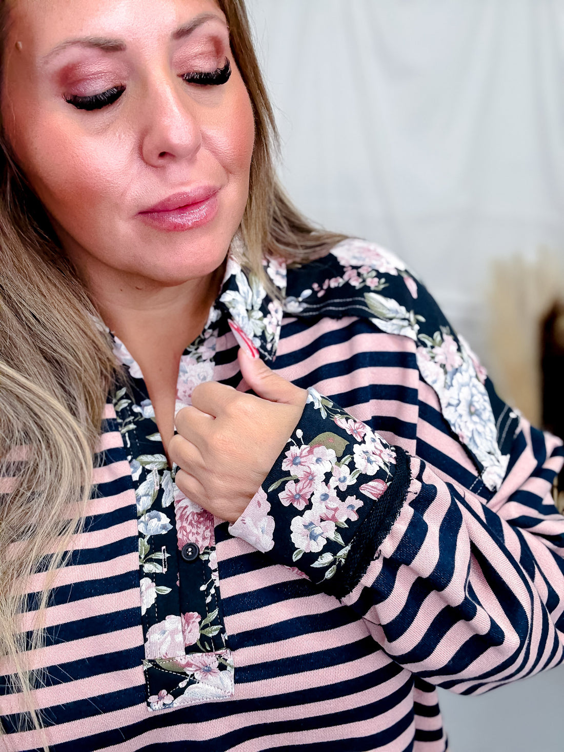 Close up of woman wearing Long Sleeve French Terry Stripped & Henley Top W/ Floral Accents in soft pink and navy stripes