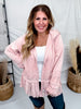 Woman wearing Dusty Pink Laced Front Tie Hooded Jacket Cardigan styled with white top and dark jeans indoors