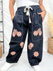 Model wearing Black Drawstring Waist Cropped Pants With Floral Appliques featuring large front pockets and comfortable fit indoors