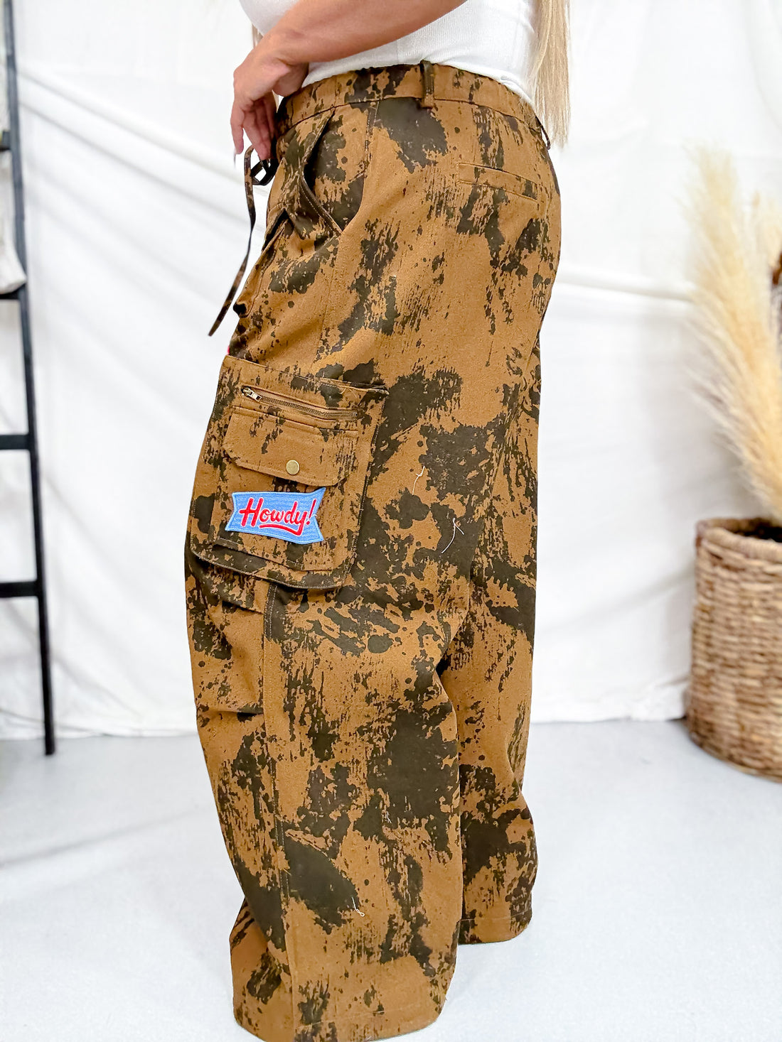 Side view of Brown Cow Camo Print Cargo Pants With Western Patches featuring cargo pocket and rustic camo design