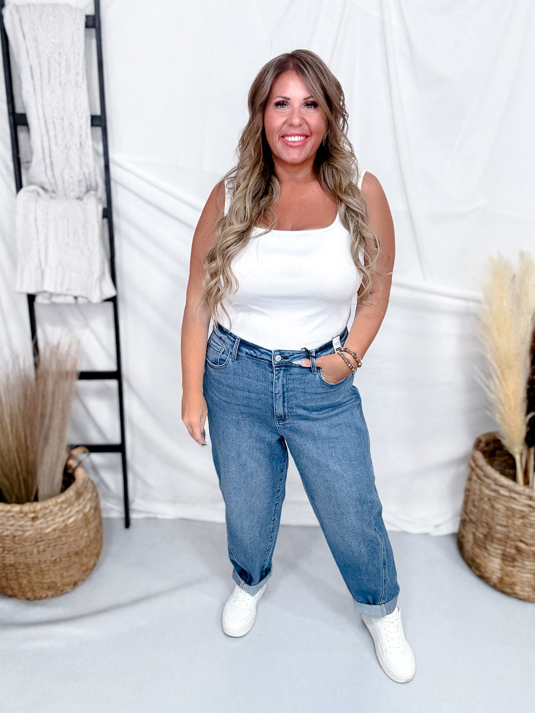 Woman wearing Judy Blue High-Waist Rigid Magic Panel Barrel Jeans styled with white tank top and casual white sneakers for relaxed look