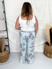 Back view of plus size woman wearing Light Blue Floral Chambray Pants With Ruffled Hem in relaxed fit indoors