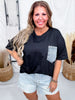 Smiling woman wearing Crewneck Denim Pocket Black Tunic Top paired with light denim shorts in casual indoor setting