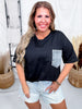Smiling woman wearing Crewneck Denim Pocket Black Tunic Top paired with light denim shorts in bright indoor setting