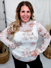 Woman smiling wearing Ivory & Taupe Floral Print Long Sleeve Mesh Top styled with black pants in casual indoor setting